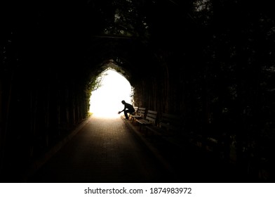 Depressed looking silhouette of a man sitting in tunnel. Dramatic concept. loneliness concept.