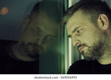 Depressed Man Looking Sadly Through The Window