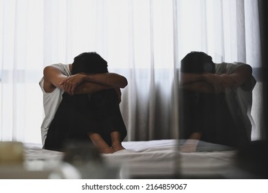 Depressed Man Sitting In The Dark Bedroom With Low Light Environment. Mental Health, Depression, Sad Emotional, Mental Illness 