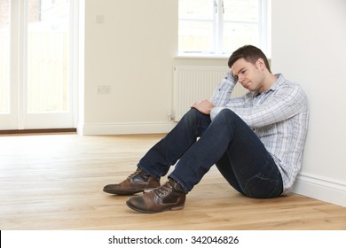 Depressed Man Sitting In Empty Room Of Repossessed House