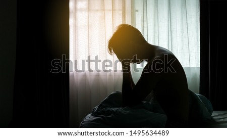 Depressed Man sitting head in hands on the bed in the dark bedroom , Stress, depression, Bipolar disorder,  concept