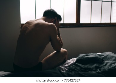 Depressed man sitting on bed in an empty room , This is major depressive disorder