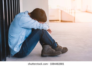 Depressed man sitting on floor while against wall, Sad man, Cry, drama concept 
