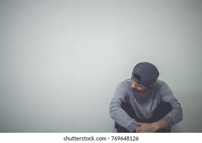 Depressed Man Sitting On Floor In An Empty Room , This Is Major Depressive Disorder.