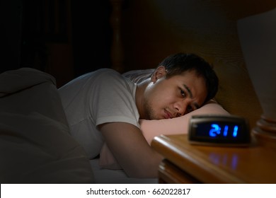Hombre deprimido que padece insomnio yace en la cama