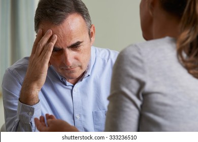 Depressed Mature Man Talking To Counsellor