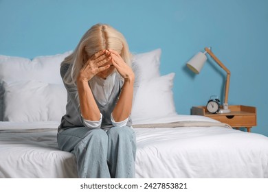 Depressed mature woman sitting in bedroom - Powered by Shutterstock