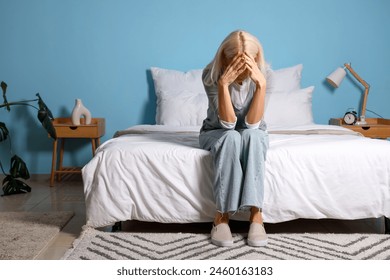 Depressed mature woman sitting in bedroom - Powered by Shutterstock