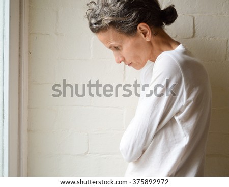 Depressed mature woman in white top Imagine de stoc © 