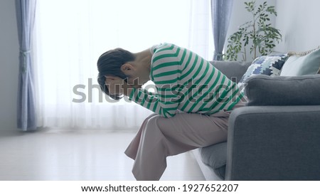 Depressed middle aged Asian woman.