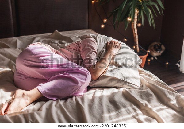Depressed\
middle-aged alone female curled up in fetal position lying in bed,\
concept of chronic insomnia, sleeping disorder, grieving about\
divorce or diagnosis disease, mental\
problems