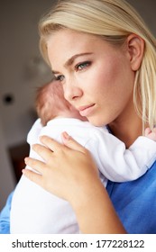 Depressed Mother Cuddling Newborn Baby