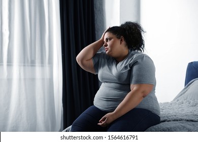 Depressed Overweight Woman On Bed At Home