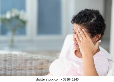 Depressive schwangere Frau sitzend auf dem Sofa zu Hause