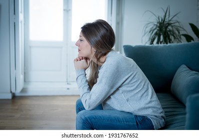 Depressed sad attractive woman crying on sofa couch at home feeling lonely tired and worried suffering depression in mental health, loneliness and isolation concept. Psychology, solitude and people