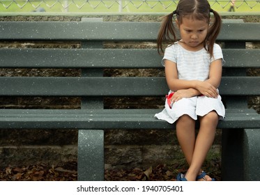 A depressed sad frustrated little girl sitting alone. Social anxiety and stressed children.