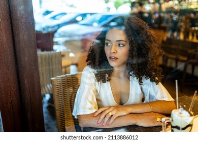 Depressed Sad Latin Woman In Bakery. Looking At The Horizon, Worried. End Of Relationship.