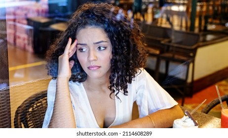 Depressed Sad Latin Woman In Bakery. Looking At The Horizon, Worried. End Of Relationship