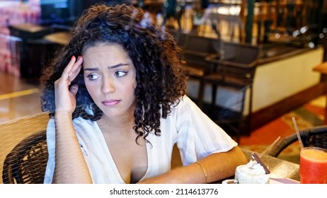 Depressed Sad Latin Woman In Bakery. Looking At The Horizon, Worried. End Of Relationship