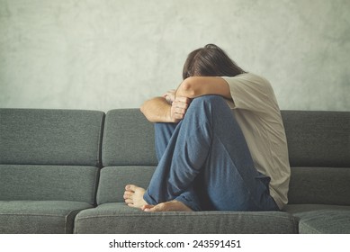 Depressed And Sad Man On The Couch In The Room, Covering Face And Crying In Despair