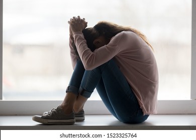 Depressed sad teen girl sit on sill crying alone at home, upset desperate young woman feeling frustrated anxious regret mistake suffer from unwanted teenage pregnancy abortion problem concept