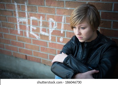 Depressed, Sad Teen Girl Sits Outside School Wall, Asking For Help