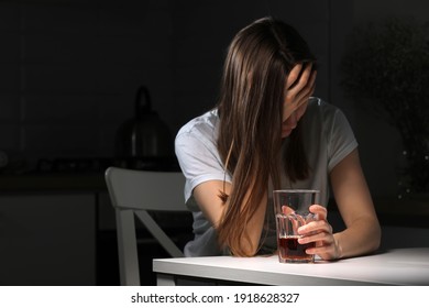 Depressed sad young addicted woman feeling bad drinking whiskey alone at home, stressed frustrated lonely female drinker alcoholic suffer from alcohol addiction having problem, alcoholism concept