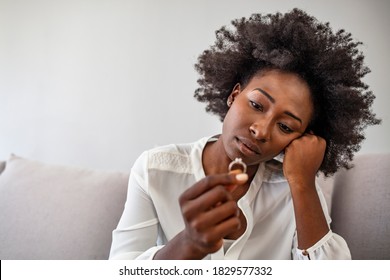 Depressed Sad Young Woman Wife Sit Alone Holding Engagement Wedding Ring In Hand Feeling Upset Disappointed Frustrated Unhappy Regret Marriage Mistake Suffer From Break Up Concept, Close Up View