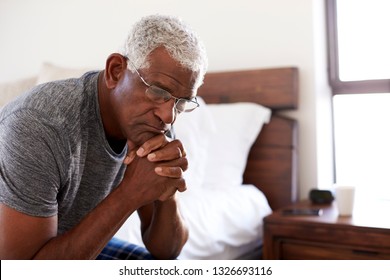 Depressed Senior Man Looking Unhappy Sitting On Side Of Bed At Home With Head In Hands - Powered by Shutterstock