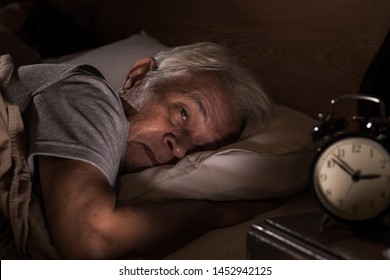 Un anciano deprimido que está acostado no puede dormir del insomnio.