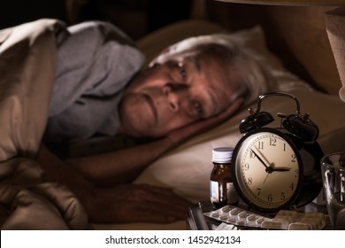 Depressed Senior Man Lying In Bed Cannot Sleep From Insomnia