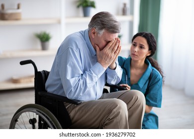 Depressed senior man in wheelchair crying, young doctor trying to help him at retirement home - Powered by Shutterstock