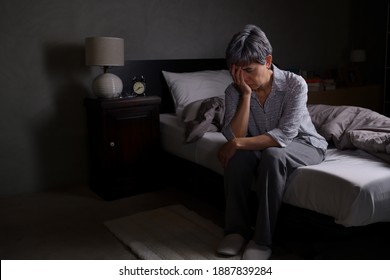 Depressed senior woman sitting in bed cannot sleep from insomnia - Powered by Shutterstock