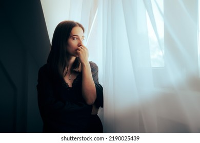 
Depressed Sorrowful Woman Looking out the Window. Unhappy person mourning and grieving from recent trauma
 - Shutterstock ID 2190025439