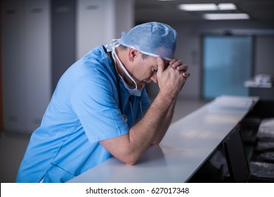 Depressed surgeon leaning on desk at hospital. Healthcare workers in the Coronavirus Covid19 pandemic
 - Powered by Shutterstock