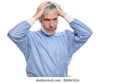 Depressed surgeon in theater garb or scrubs holding his hands to his head with a grim expression isolated on white - Shutterstock ID 206967616