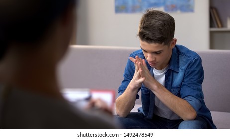 Depressed teen visiting psychologist helping to cope with, problems awkward age - Shutterstock ID 1492478549