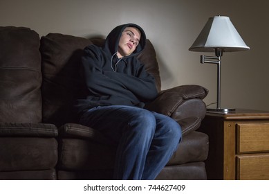 Depressed Teenage Boy Sitting On A Couch