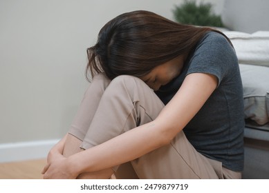 Depressed teenage sitting on the floor feeling sad. - Powered by Shutterstock