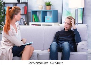 Depressed Teenager Having Therapy Session With Therapist At Office