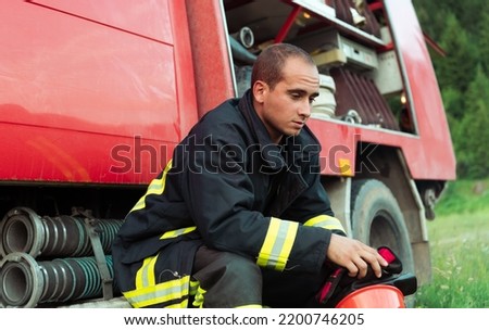 depressed and tired firefighter near fire truck. 