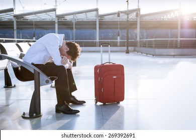 Depressed traveler waiting at airport after flights delays and cancellations