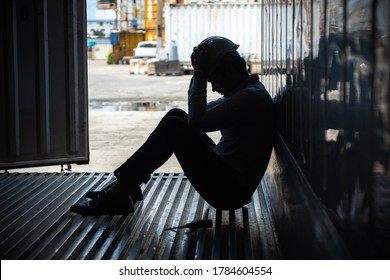 Depressed And Tried Foreman Or Business Man Sitting In Side Container In Shipyard Logistic Factory Because Losing His Job Or Fired. Worker Or Officer Sad.