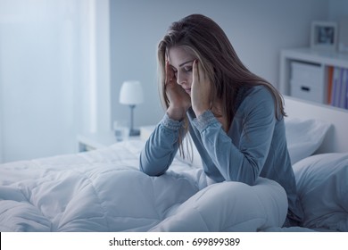 Depressed woman awake in the night, she is exhausted and suffering from insomnia - Shutterstock ID 699899389