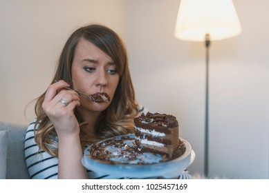 Depressed woman eats cake.  Sad unhappy woman eating cake. Sad woman eating sweet cake. Close up of woman eating chocolate cake. food, junk-food, culinary, baking and holidays concept 