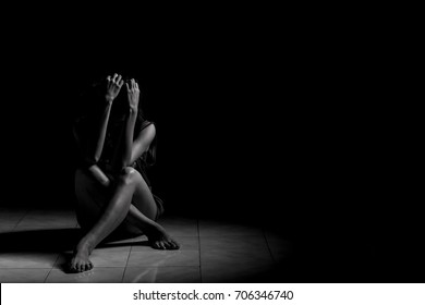 A Depressed Woman Is Sitting Alone In A Dark Room.