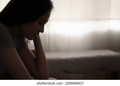 Depressed Woman Sitting Alone On The Bed With Hands On Head Feel Stress, Sad And Worried In The Dark Bedroom And Low Light Environment