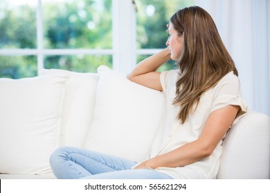 Depressed woman sitting on sofa after argument with partner at home