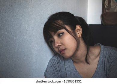 Depressed woman sitting at room corner.