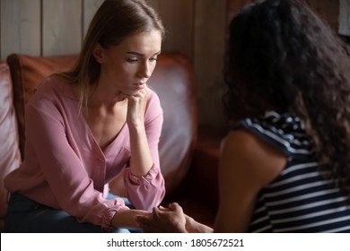 Depressed woman visiting psychologist, talking about problems, African American counselor therapist holding patient hands, comforting, expressing understanding and empathy, personal therapy session - Shutterstock ID 1805672521
